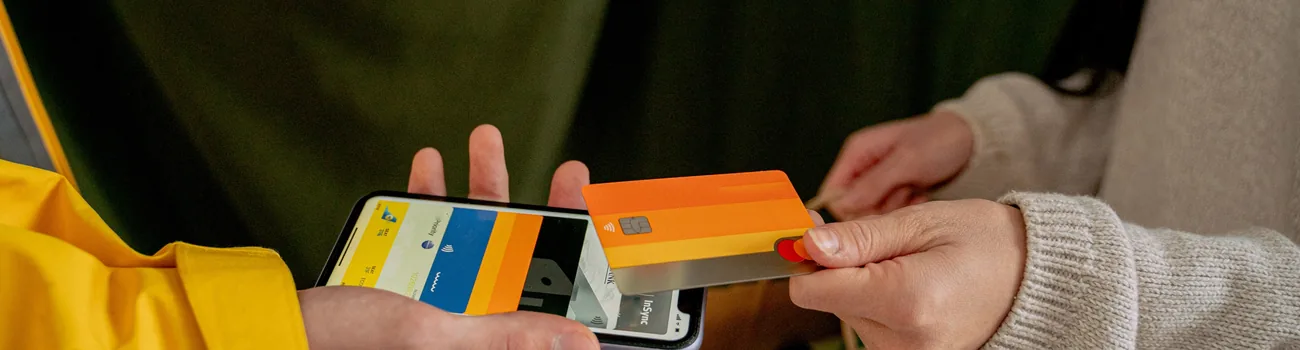 Paying with a card in front of a mobile banking app